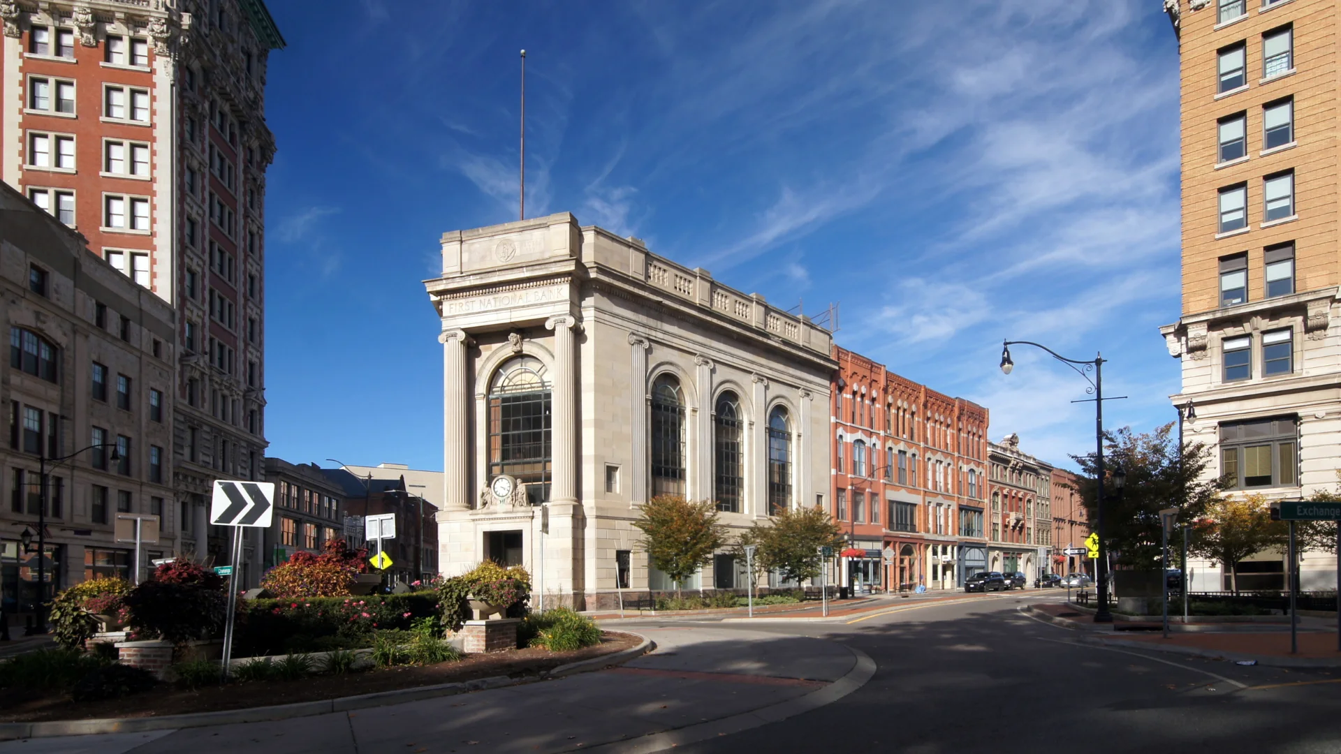 A large building featuring a prominent clock tower against a clear blue sky.