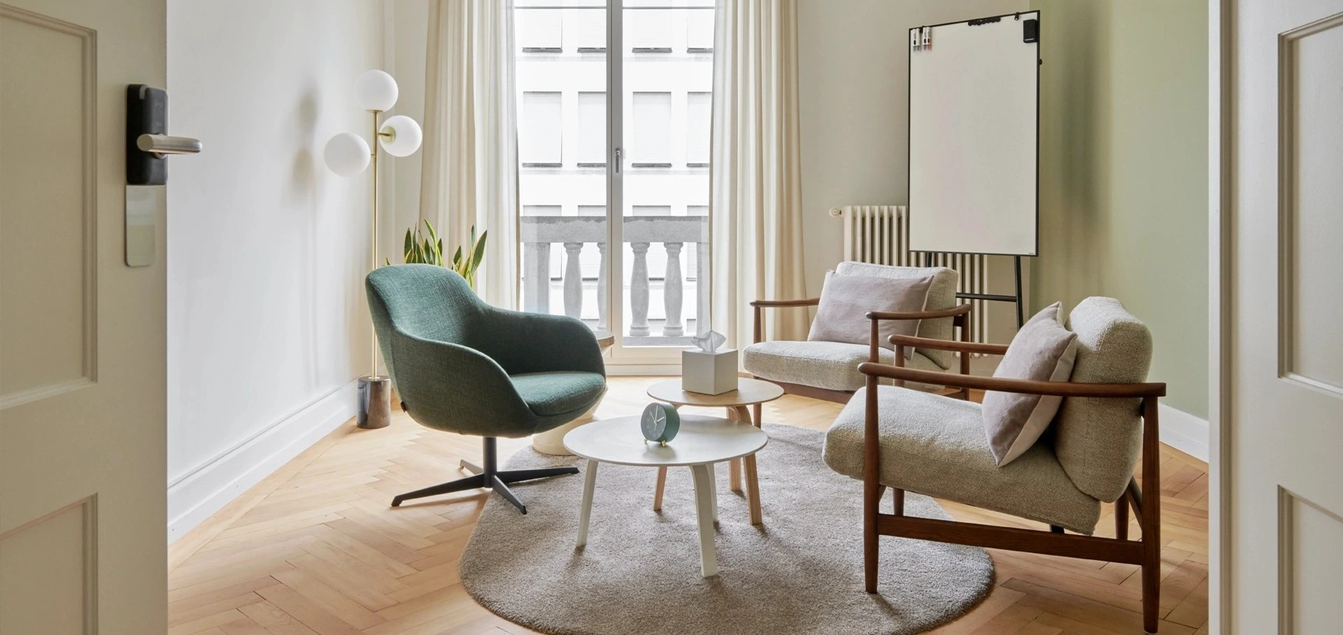 A cozy living room featuring a green chair and a white table, creating a welcoming atmosphere.